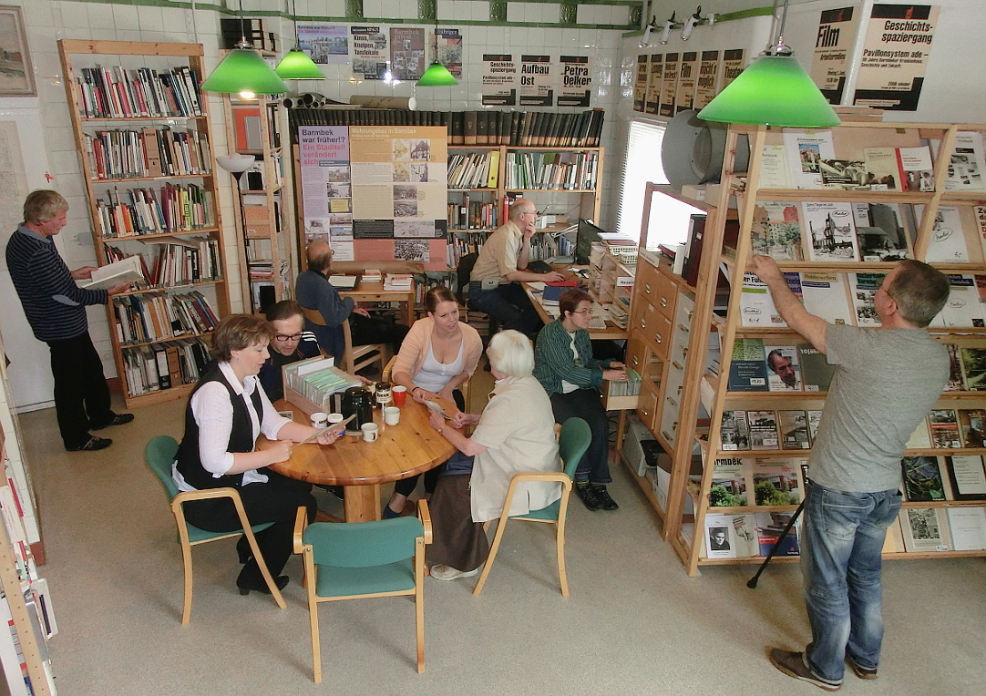 Menschen arbeiten, lesen und tauschen sich in der Geschichtswerkstatt Barmbek aus.